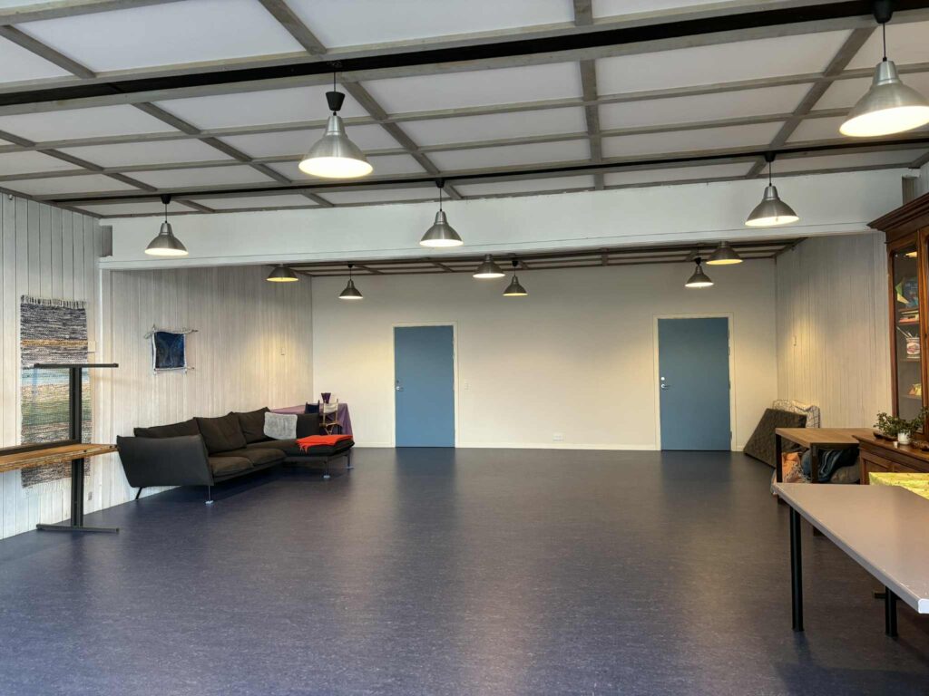 Auditoriet, en stor sal med blåt gulv og loftlamper